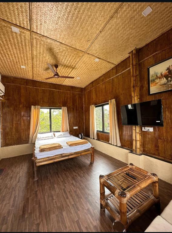 a bedroom with a bed and a tv in it at Ashaya Agro Farms in Umberpāda
