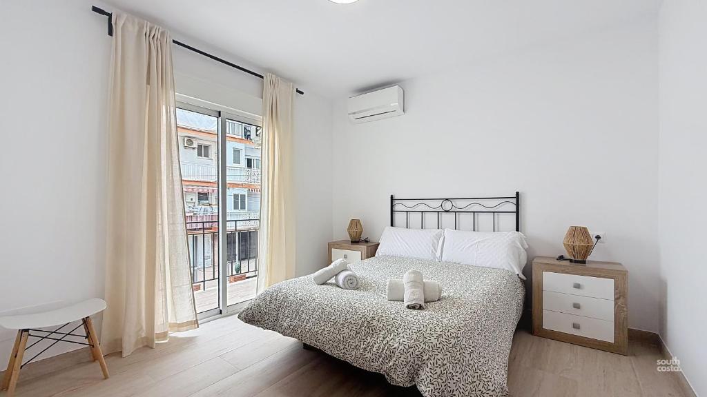 a bedroom with a bed and a large window at Casa Playa Torrecilla by South Costa in Nerja