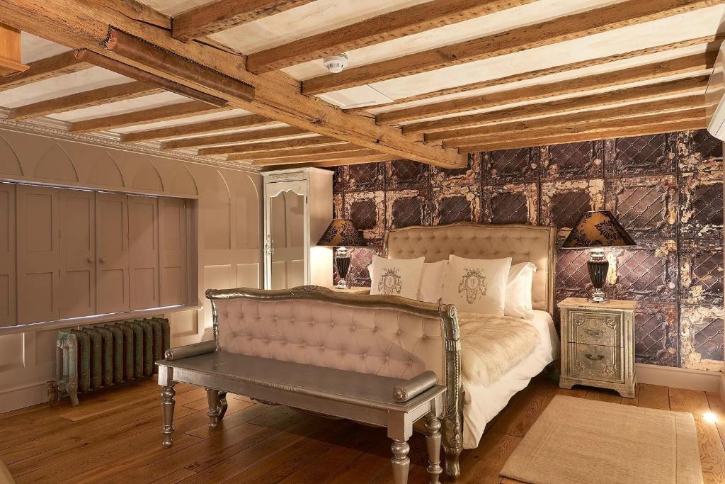 a bedroom with a bed and a bench in it at Broad Leys in Aylesbury