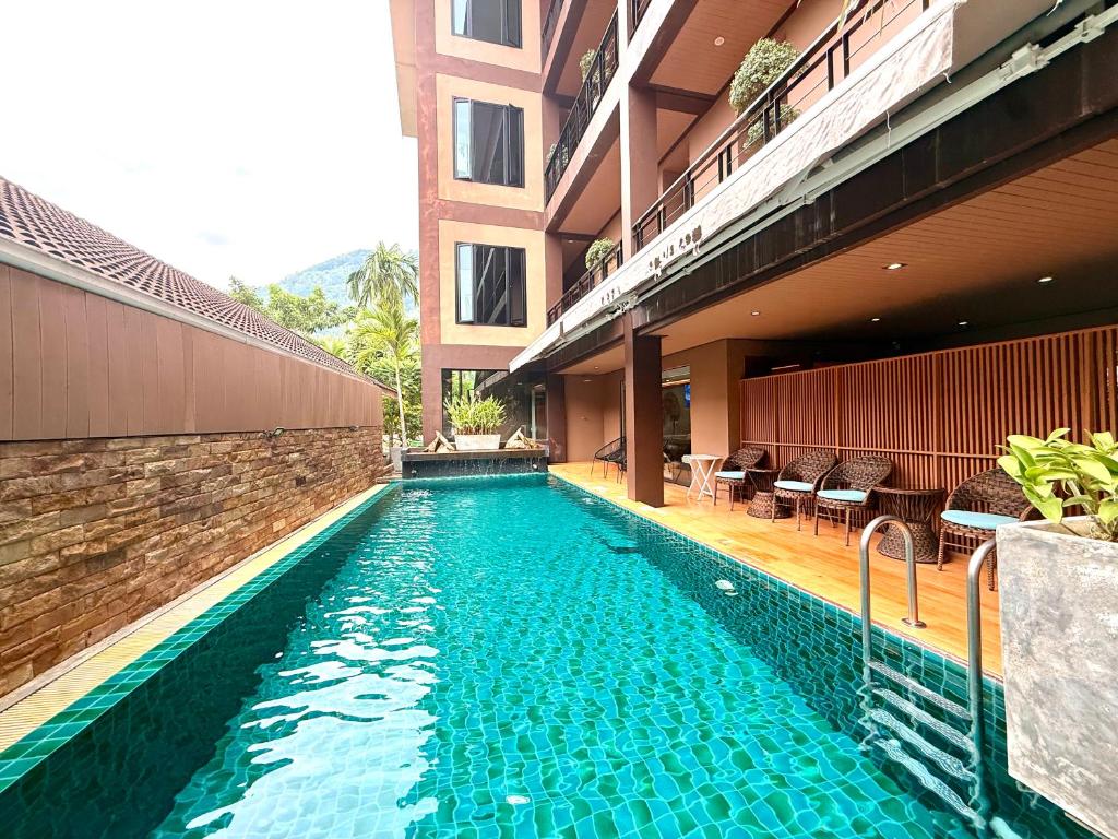a swimming pool in front of a building at Westkey Kamala Hotel in Kamala Beach