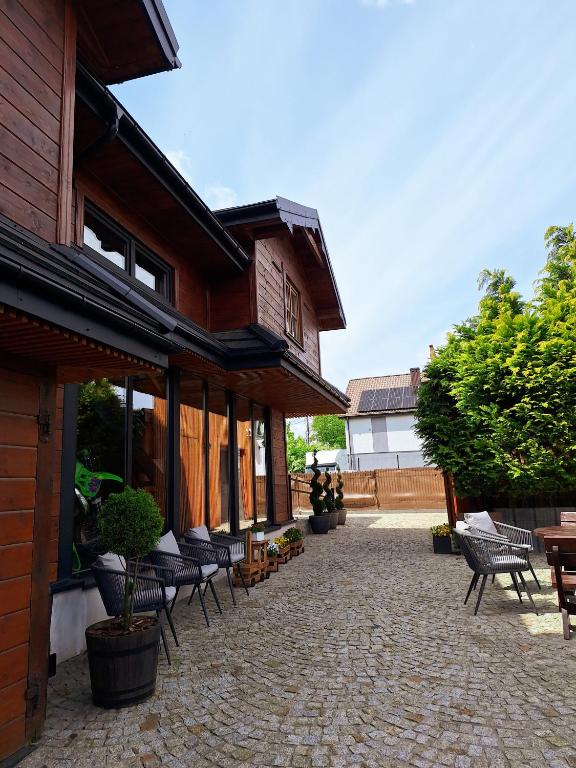 een terras met stoelen en tafels en een gebouw bij MX Pokoje in Lipno