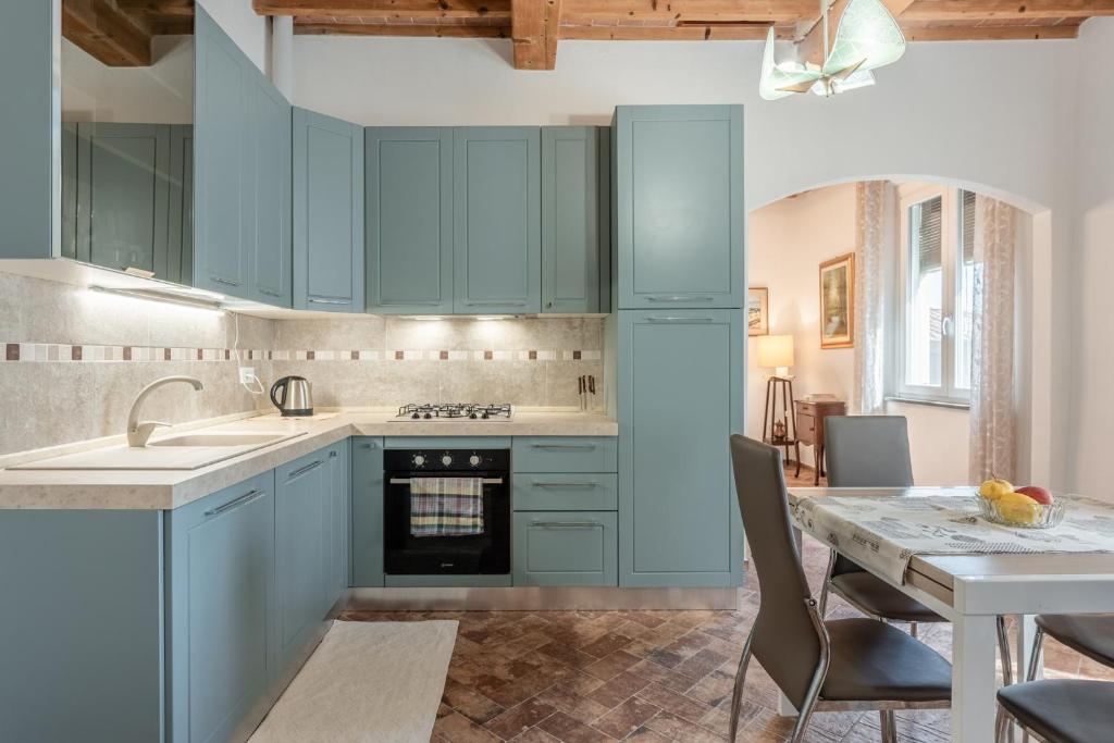 a kitchen with blue cabinets and a dining table at Casa Loretta Vicopisano in Vicopisano