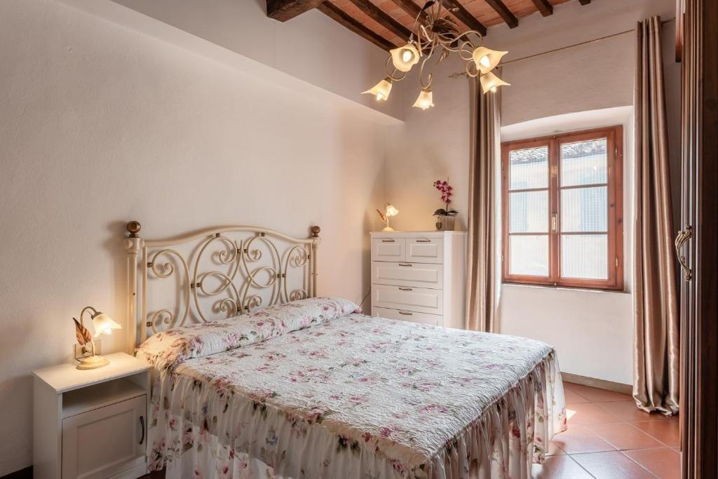 a bedroom with a bed and a dresser and a window at Casa Ilaria Vicopisano in Vicopisano