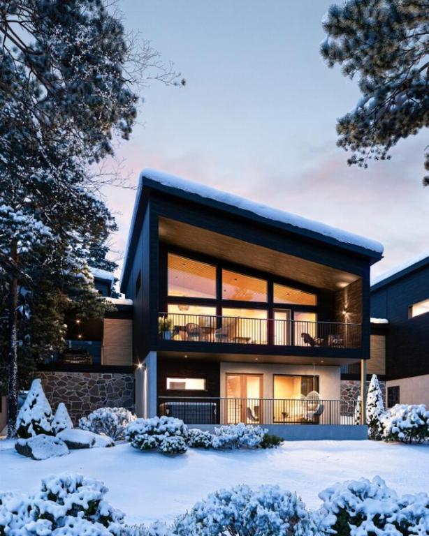 a house with a balcony in the snow at TAHKO LAKESIDE VILLA D 2 in Tahkovuori