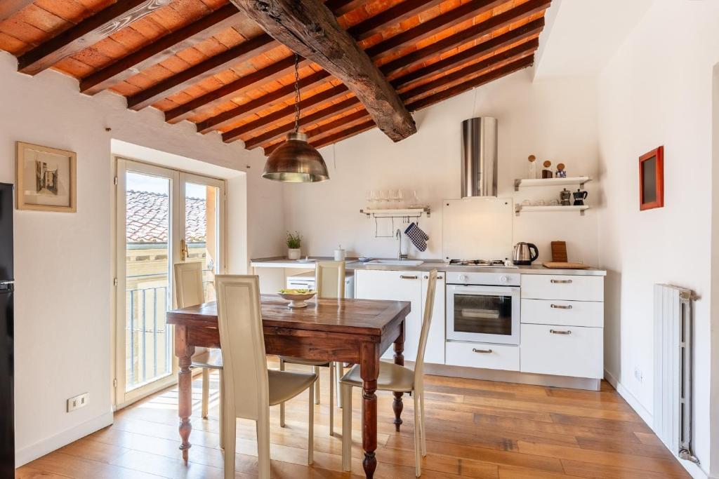 a kitchen with a wooden table and a wooden ceiling at Mordini Loft - 3 Bedrooms - Lucca in Lucca