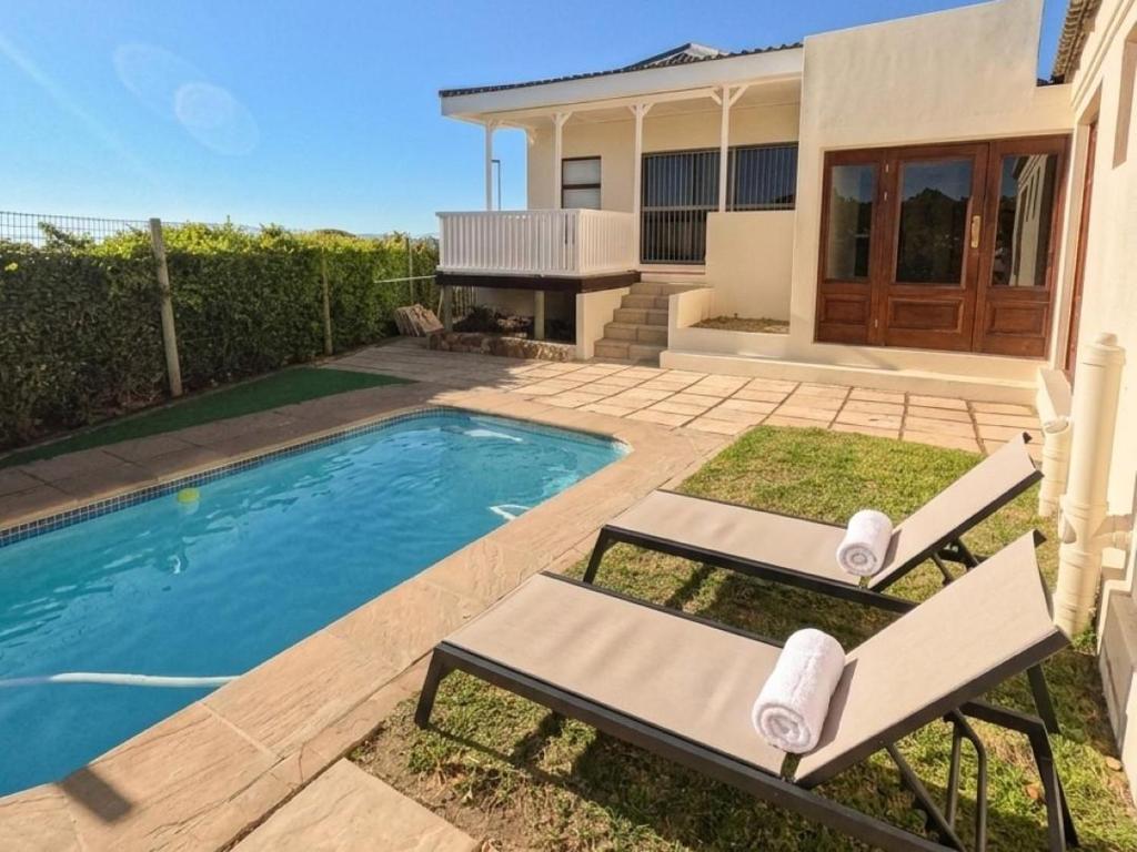 a house with a swimming pool and two lounge chairs at Winford Manor in Murdoch Valley