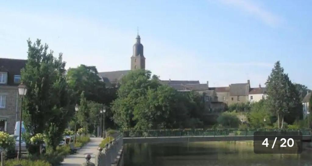 a view of a city with a river and buildings at Le gîte de la Roche in Putanges