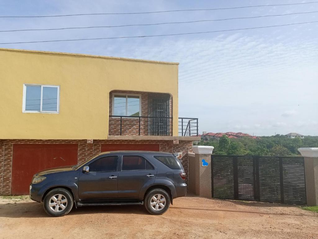 a black suv parked in front of a house at Executive Apartment in Cape Coast