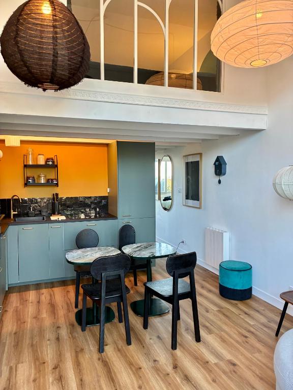 a kitchen and dining room with two tables and chairs at Blue dream in Carantec