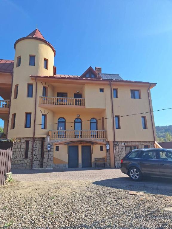 a building with a car parked in front of it at Vila Cristal in Târgu Ocna