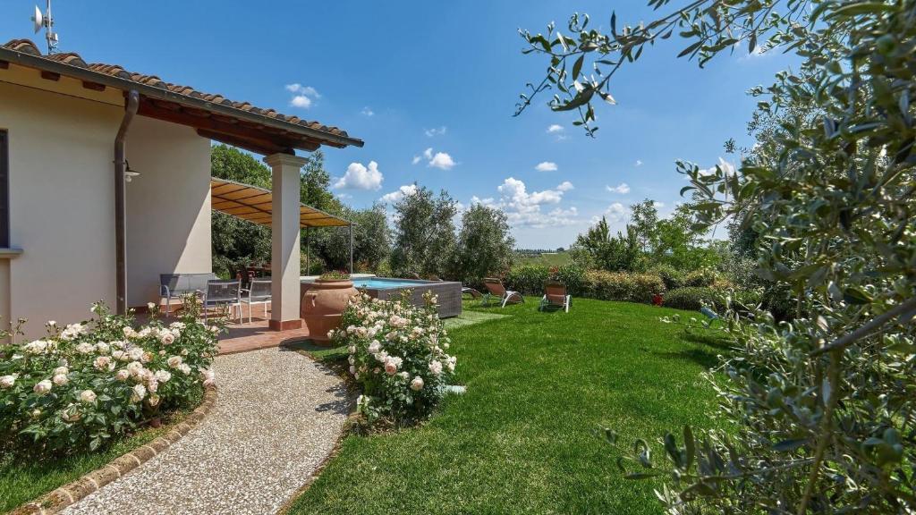 a backyard with a pool and green grass at Petriolo - Tuscany Hills & Jacuzzi in Cerreto Guidi