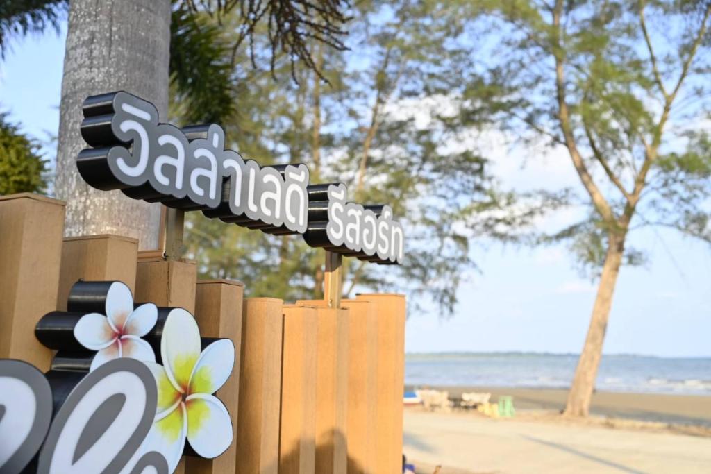 a couple of street signs in front of a beach at Laydee Resort in Chumphon