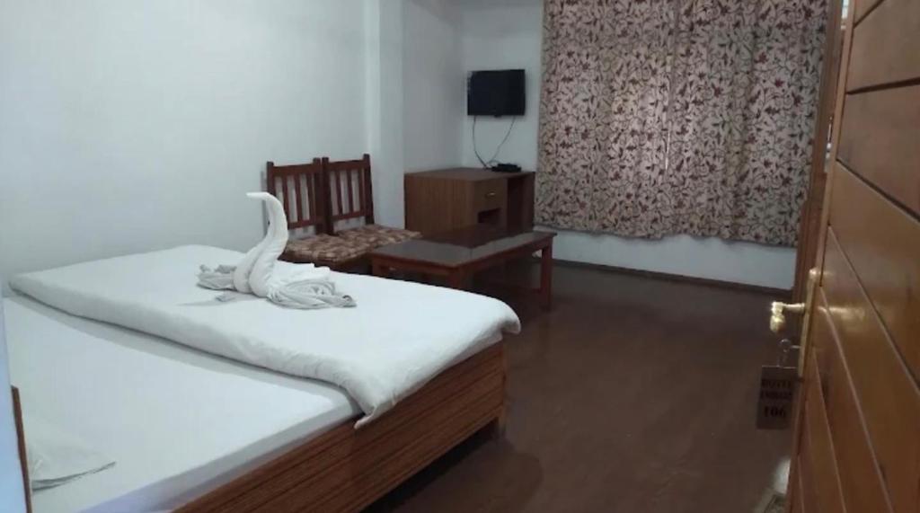 a bedroom with a bed and a chair and a window at Hotel imroz in Srinagar