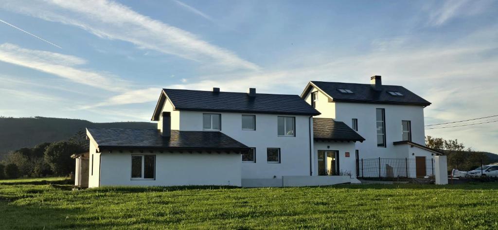 a white house with a black roof in a field at Quinta Cuadrao in Cartavio