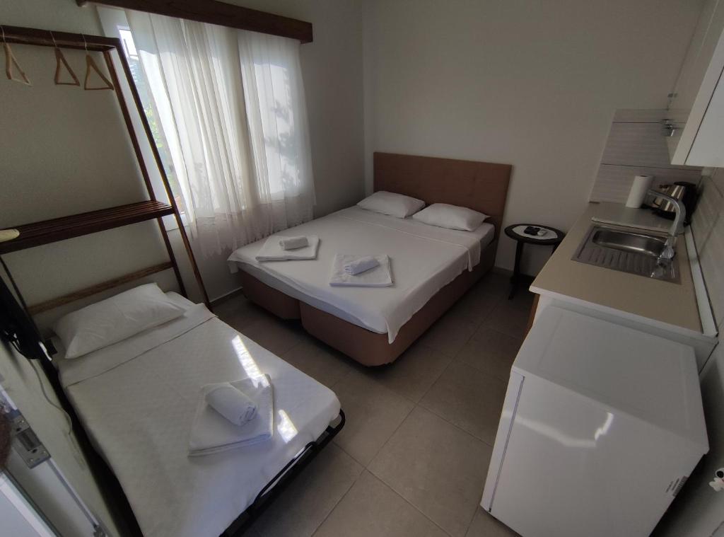 a hotel room with two beds and a sink at Villa Rain Bahce Suit Oda in Çeşme