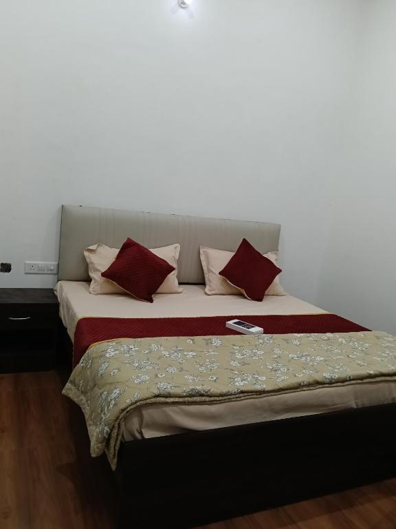 a bed with red and white pillows on it at galaxy hotel jobner in Jobner