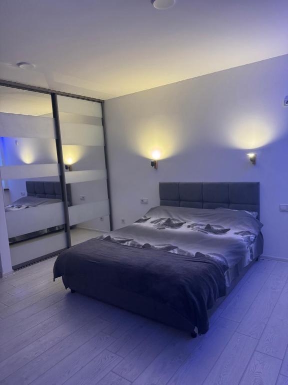 a bedroom with a large bed and a large mirror at Гагарина 119 in Dnipro