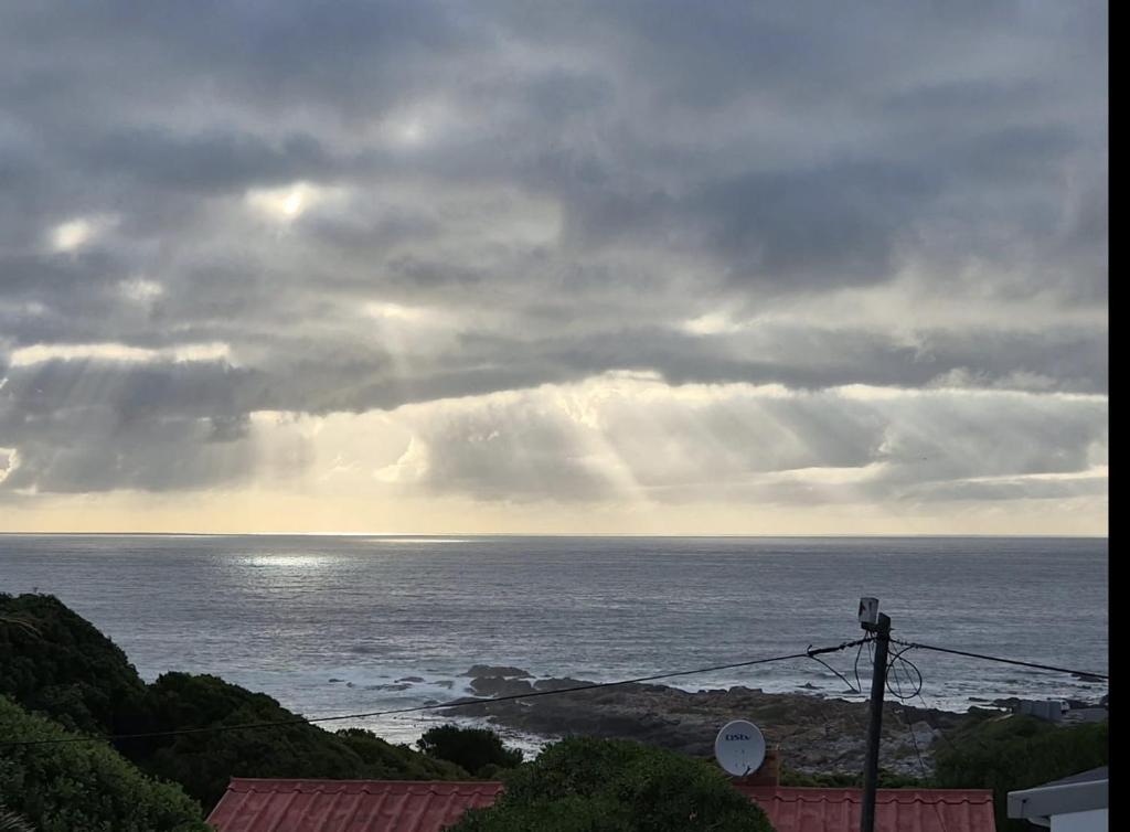 a view of the ocean under a cloudy sky at Net Genoeg in De Kelders