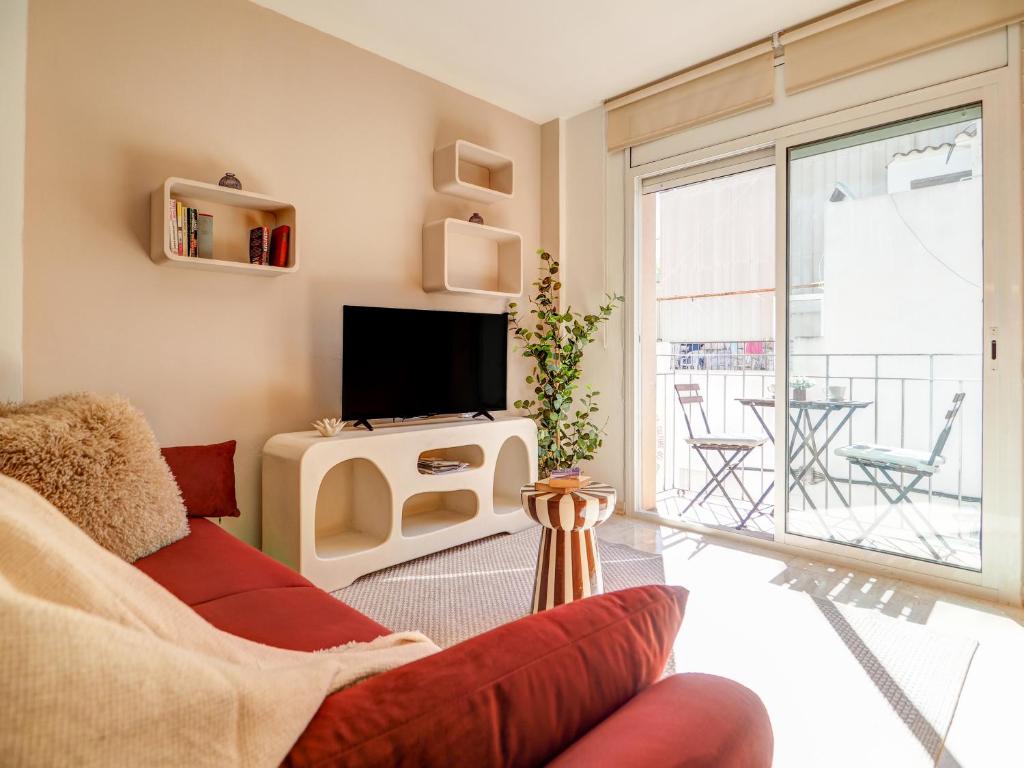 ein Wohnzimmer mit Sofa und Fernseher in der Unterkunft Bonaire Apartment by Hello Homes Sitges in Sitges