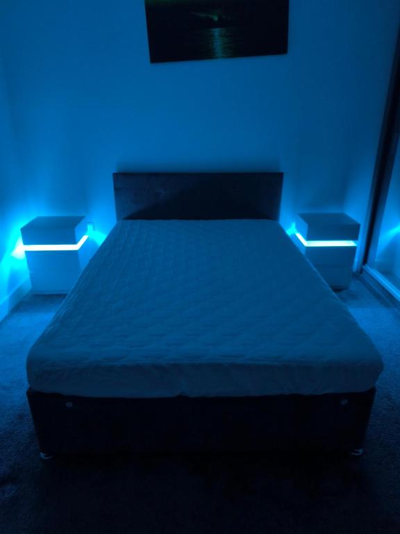 a bed in a room with blue lights at Teddy's in Immingham