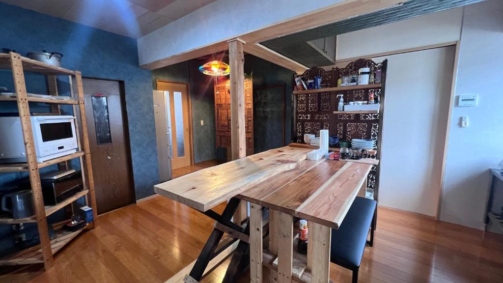 a dining room with a wooden table in a room at ゲストハウス のまー in Komagane