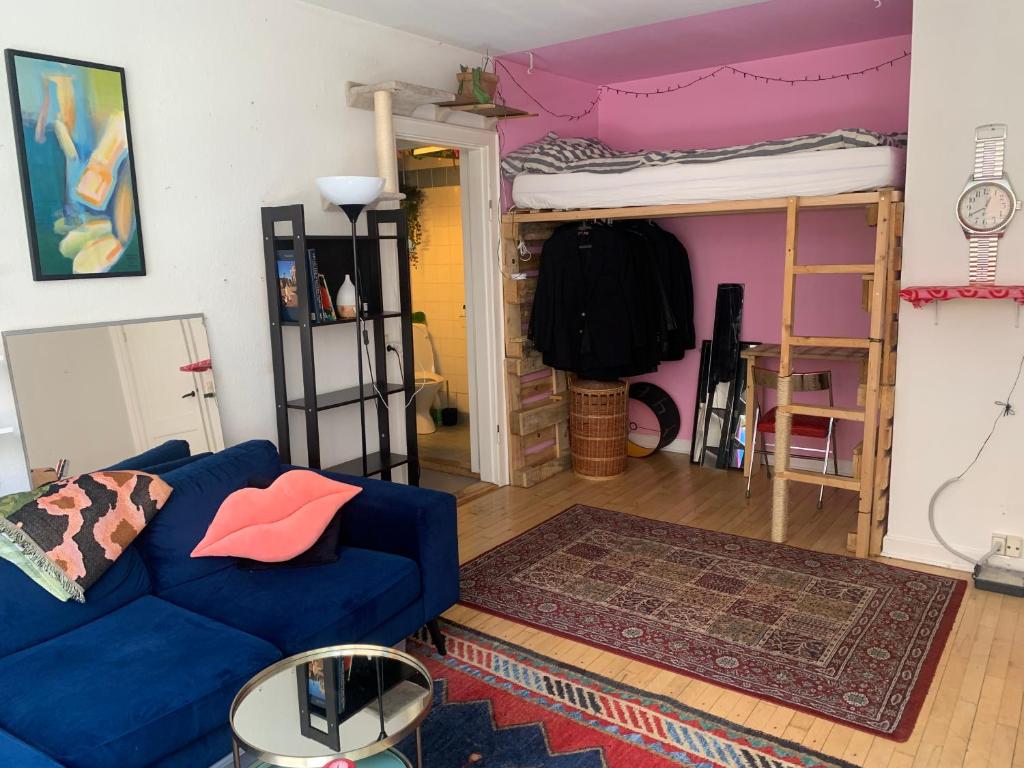 a living room with a couch and a bunk bed at Studio apartment by the metro in Copenhagen