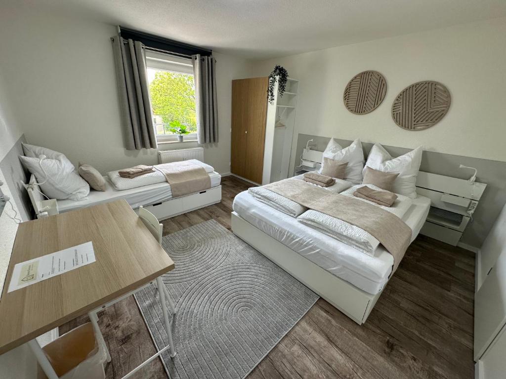 a small room with two beds and a table at Hostel by BookieBooking in Wiesbaden