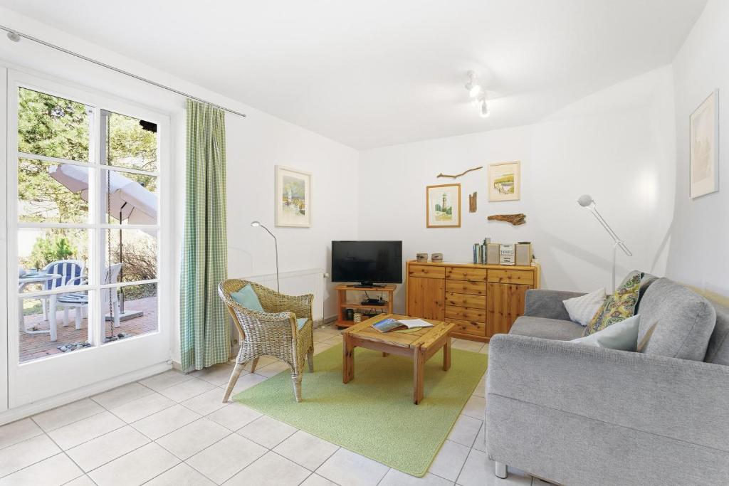 a living room with a couch and a tv at Achtern Diek 13a - Wohnung 2 in Müggenburg