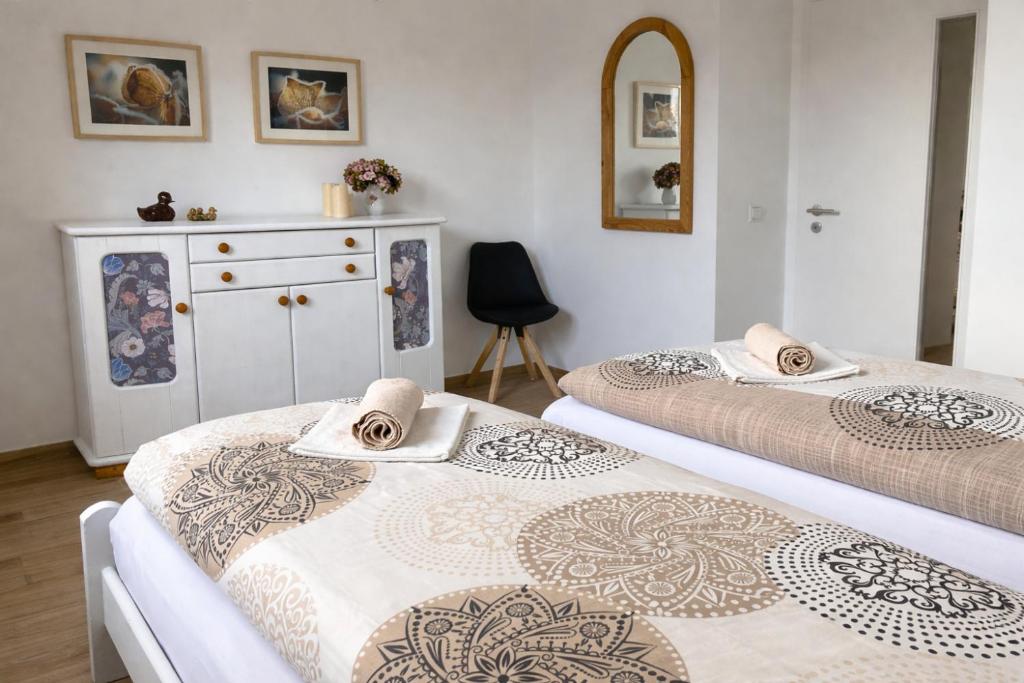 a room with two beds and a dresser at Andi's Auszeit in Dörpen