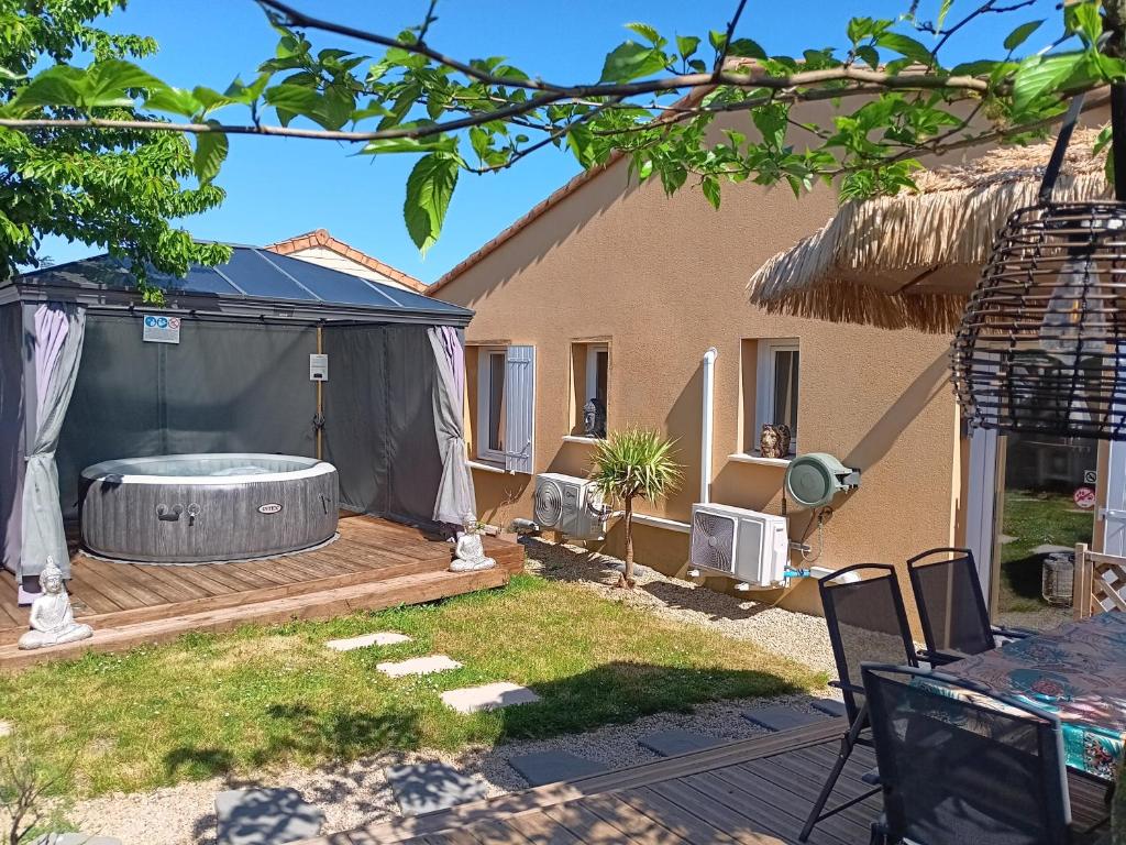 a backyard with a tub in a gazebo at Le Petit Marais in Échiré