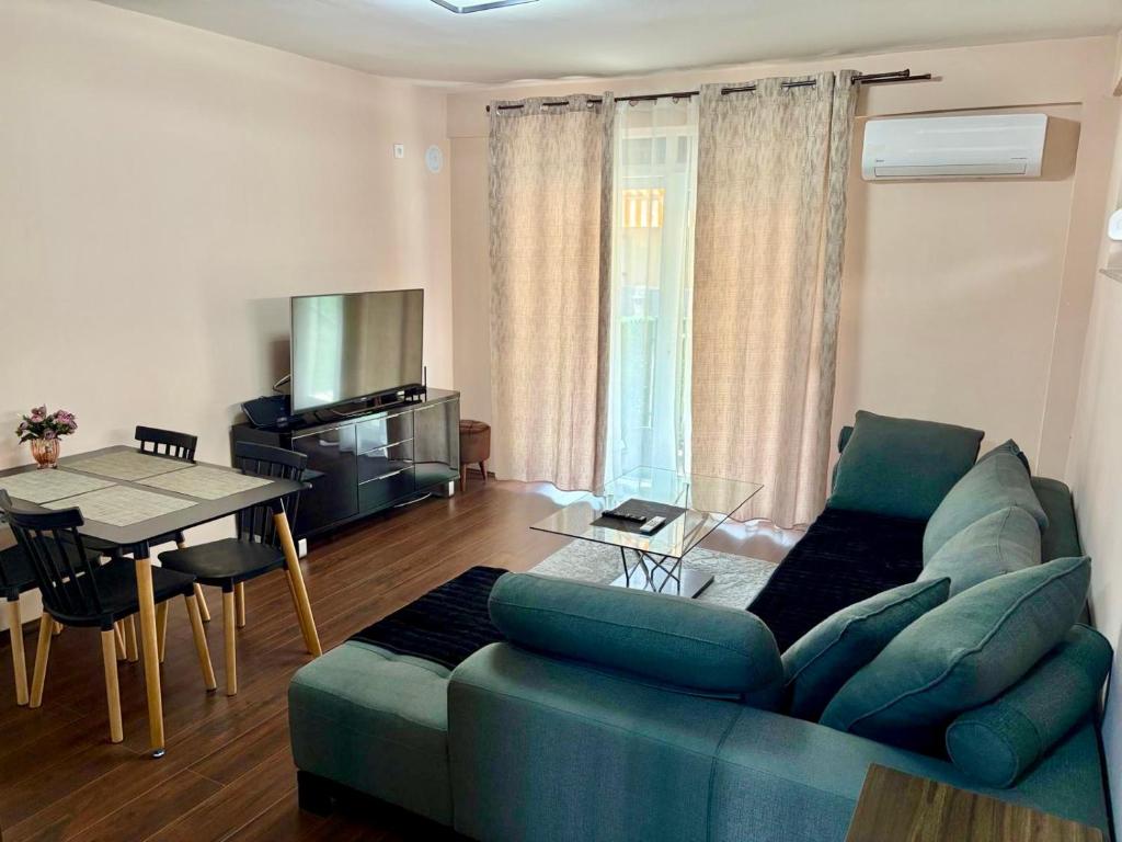 a living room with a green couch and a table at Juliya Apartment in Kavadarci
