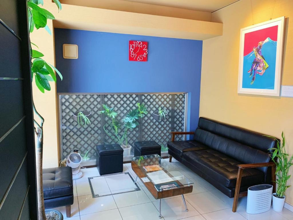 a living room with a black couch and a table at Web Hotel Tokyo Asakusabashi in Tokyo