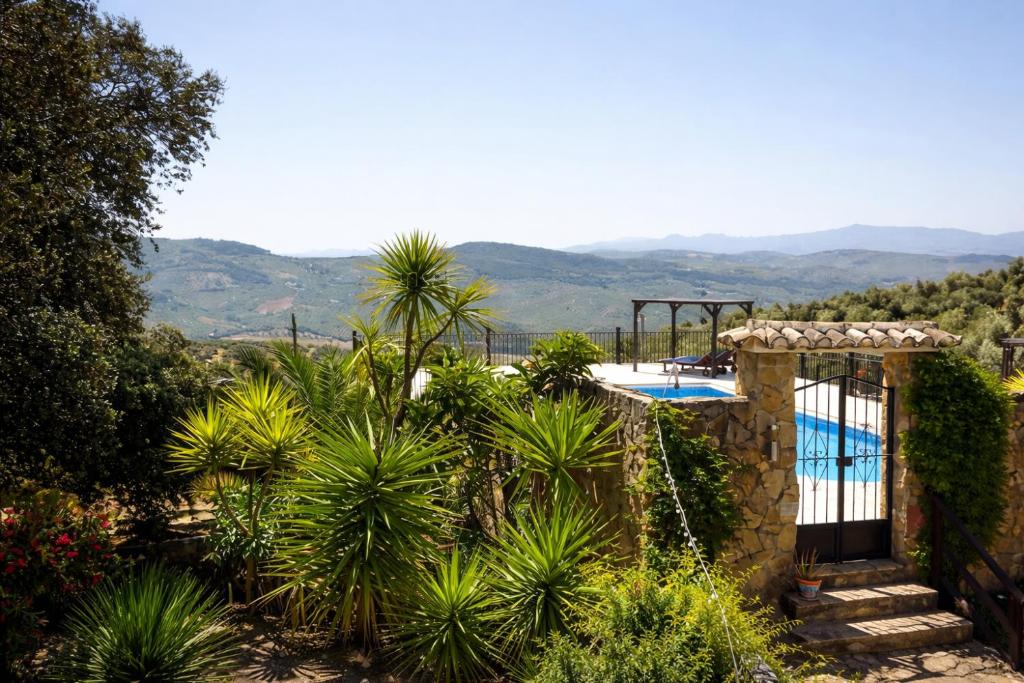 a villa with a pool and mountains in the background at Cortijo Sol y Olivo spacious exclusive private pool retreat in Algarinejo