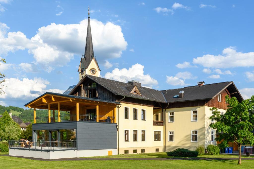 a large building with a church with a steeple at Luise Wehrenfennig & Haus EvA in Bad Goisern