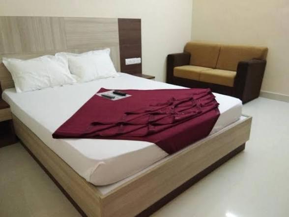 a large bed in a room with a couch at grand empark in Bangalore