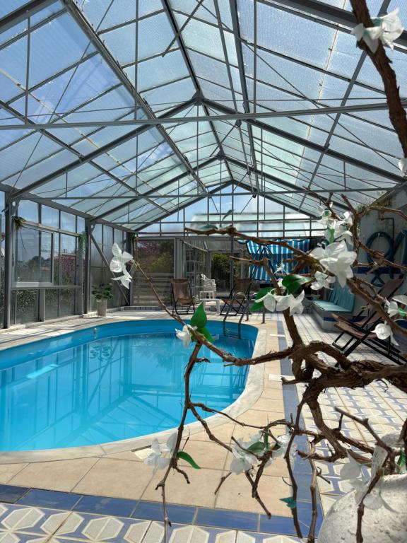 a conservatory with a pool and a glass roof at Villa Noza Kalamos in Kalamos