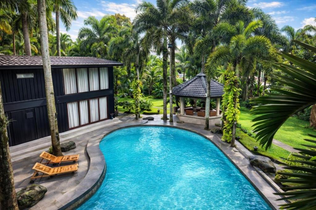 a swimming pool with a gazebo and palm trees at Novella Tagaytay in Tagaytay