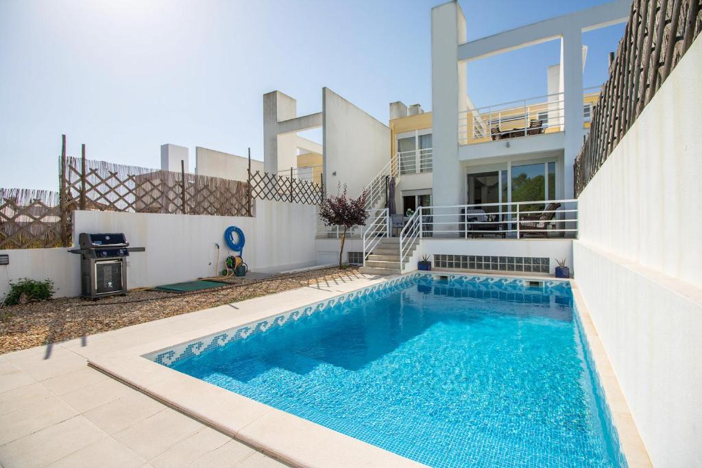 a house with a swimming pool in front of a house at Villa Granada by Algarve Holidays in Almancil