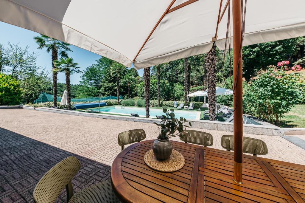 a wooden table with chairs and a vase on it at Villa Pegasus in Turin