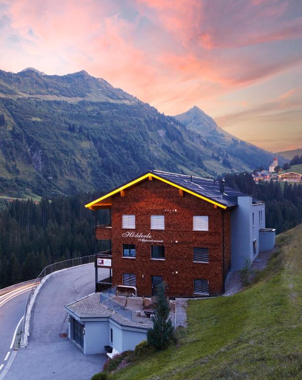 a building on the side of a hill with a road at Hölderle Damüls in Damuls