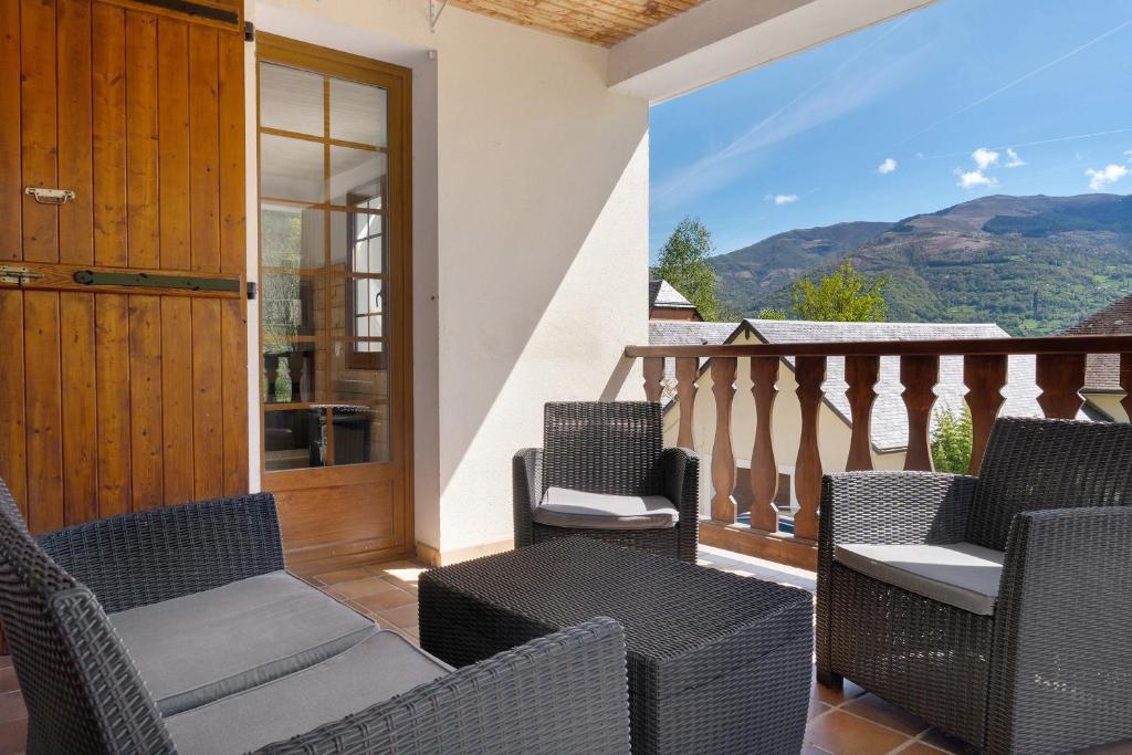 a balcony with chairs and a door with a view at Maison L'arrieulat in Argelès-Gazost