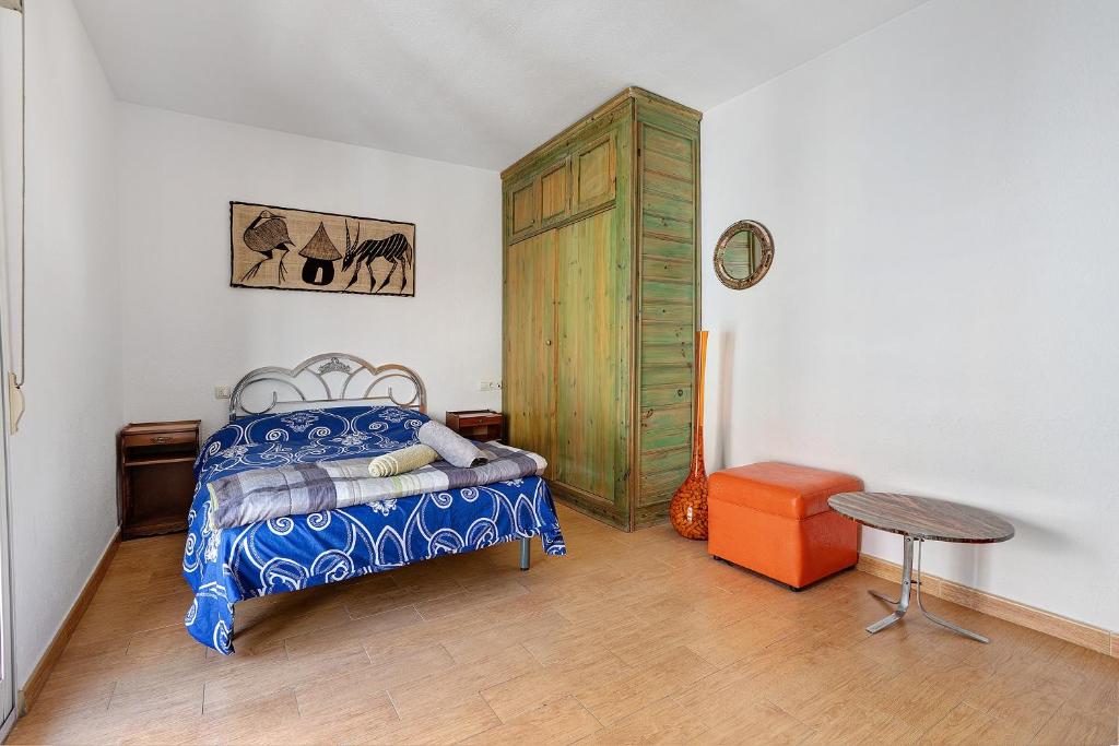 a bedroom with a bed and a wooden cabinet at Casacuéntame in Granada