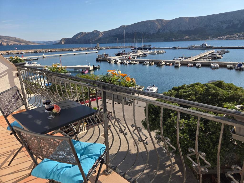 a balcony with a table and chairs and a marina at Apartment Borna in Baška