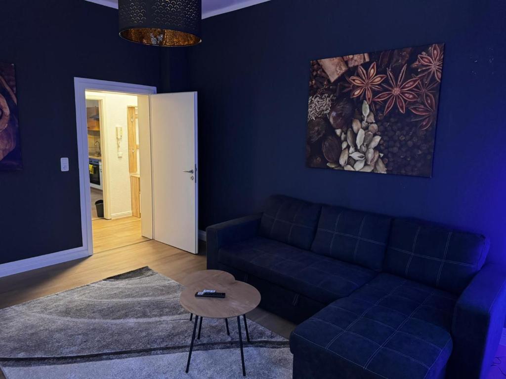 ein blaues Wohnzimmer mit Sofa und Tisch in der Unterkunft Stadtoase 2 in Wittenberge