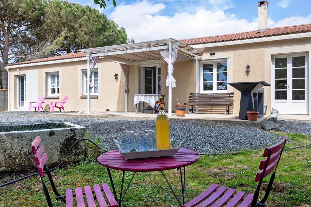 a table with a vase on it in a yard at Chambre d'hôtes Les Loges in Luçon