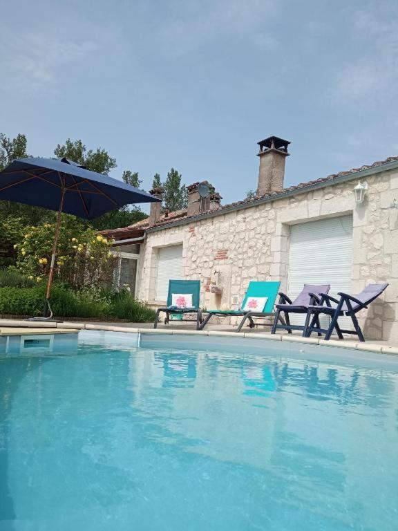 two chairs and an umbrella next to a swimming pool at L isaro in Anthé