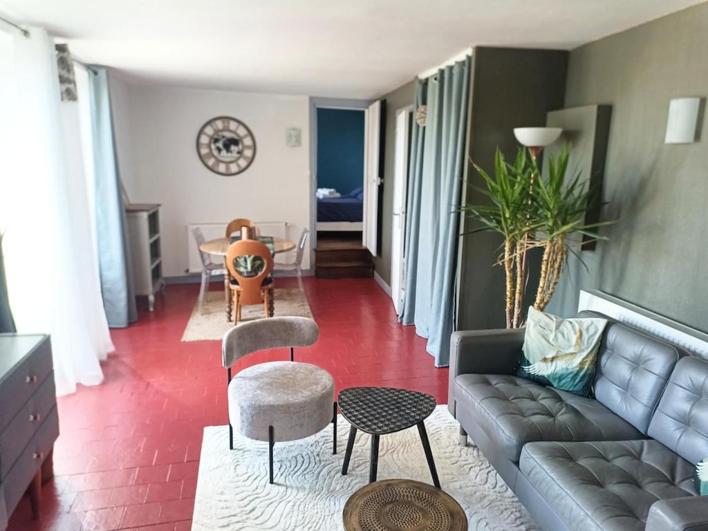 a living room with a couch and a table at Maison les Alouettes in Nevers