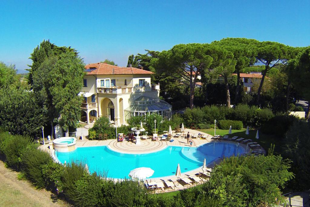 una casa grande con piscina frente a ella en Villa Mazzanta Relais & Residence, en Vada