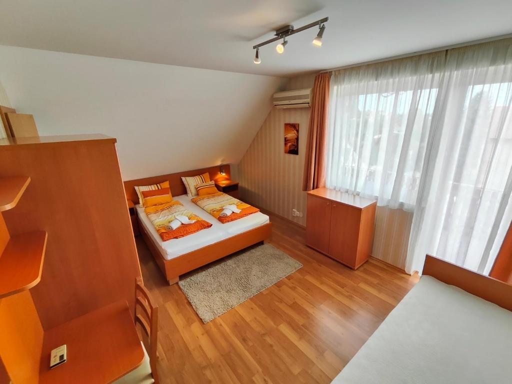 a small bedroom with a bed and a window at Sárga Apartman Ház in Balatonfüred