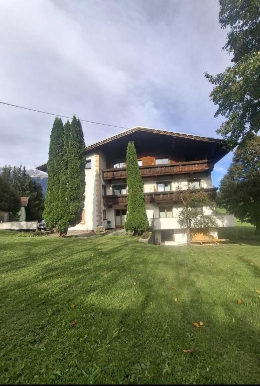 a building with a large lawn in front of it at Apartment Tirol #Spielanger Hof# in Weer